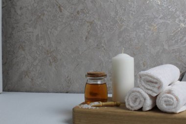 Vücut masajı için yağ beyaz mum havluları salyangoz salyangoz tahta tepside gri arka plan görünümlü. Spa rahatlama masajı. Vücut bakımı.