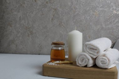 Vücut masajı için yağ beyaz mum havluları salyangoz salyangoz tahta tepside gri arka plan görünümlü. Spa rahatlama masajı. Vücut bakımı.