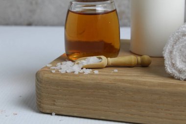 Vücut masajı için yağ beyaz mum havluları salyangoz salyangoz tahta tepside gri arka plan görünümlü. Spa rahatlama masajı. Vücut bakımı.