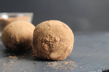 Kakaoda çikolatalı kek siyah bir arka planda siyah bir taşın üzerinde uzanıyor..