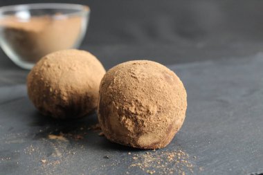 Kakaoda çikolatalı kek siyah bir arka planda siyah bir taşın üzerinde uzanıyor..