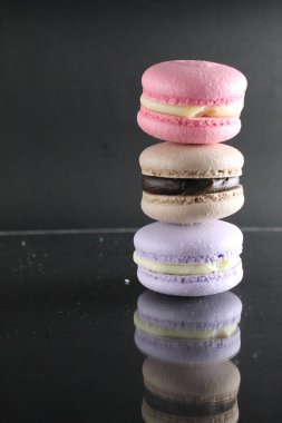 Siyah parlak bir arkaplanda, metin ve kopyalanacak bir yeri olan üç badem kurabiyesi..