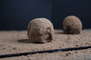 İki çikolatalı kek, siyah bir arka planda kakao tozunun üzerinde uzanıyor ve mesaj için yer var. Evde, mutfakta, kafede tatlı pişirmek..