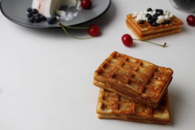 Kahvaltı nefis. Atıştırmalık iki yumuşak Belçika waffle 'ı yaban mersinli peynirli süzme peynirin yanında üstüste uzanır metin ve kopyalanma alanı ile.