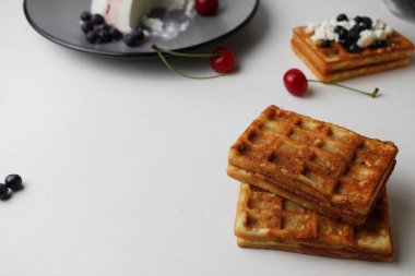 Kahvaltı nefis. Atıştırmalık iki yumuşak Belçika waffle 'ı yaban mersinli peynirli süzme peynirin yanında üstüste uzanır metin ve kopyalanma alanı ile.