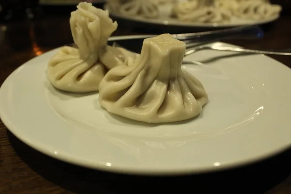 Twee Khinkalen Liggen Een Witte Plaat Naast Vork Het Mes — Stockfoto