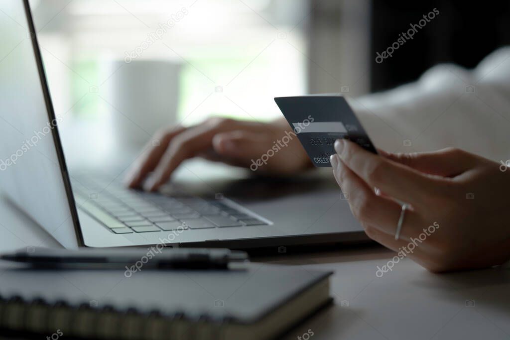 Female hands holding credit card and using laptop. Online shopping