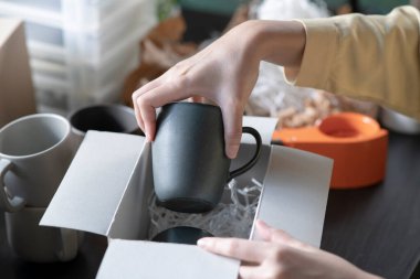 Kadın iş sahibinin müşteriye nakliye siparişini paketlediği yakın plan görüntüsü. Mağaza deposunda teslimat için kadın girişimci paketleme kutusu.