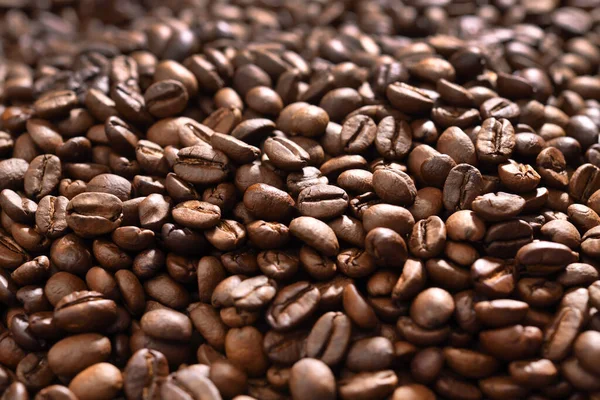 Pile of roasted coffee beans. Freshly roasted strong aromatic coffee beans in a large pile.