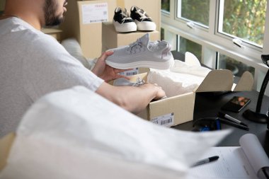 Erkek çevrimiçi mağaza küçük işletme sahibi ambalaj paketi posta kutusu teslimat paketini masanın üzerinde hazırlıyor. E-ticaret sevkiyat hizmeti konseptini düşürdü.                                                                              