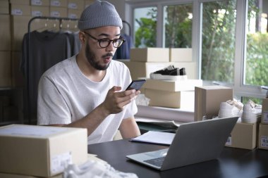 Başarılı bir e-ticaret Asyalı iş adamı. Genç ve mutlu bir satıcı müşterilerden emir alıyor. Deposunda çalışan nakliye şirketini bırak..