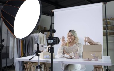 Genç ve çekici Asyalı blog yazarı ya da video blogcusu kameraya bakıp merhaba diyor. Modern iş kadını pazarlama için sosyal medyayı kullanıyor. Sosyal medya kavramı üzerinde iş çevrimiçi etkileyiciName.