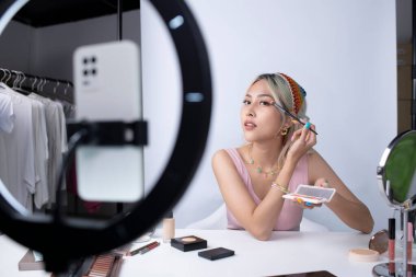Genç ve güzel Asyalı kadın ve profesyonel güzellik makyaj sanatçısı vlogger veya blog yazarı web sitesinde veya sosyal medyada paylaşmak için makyaj dersi alıyorlar. Sosyal medya kavramı üzerinde iş çevrimiçi etkileyiciName.