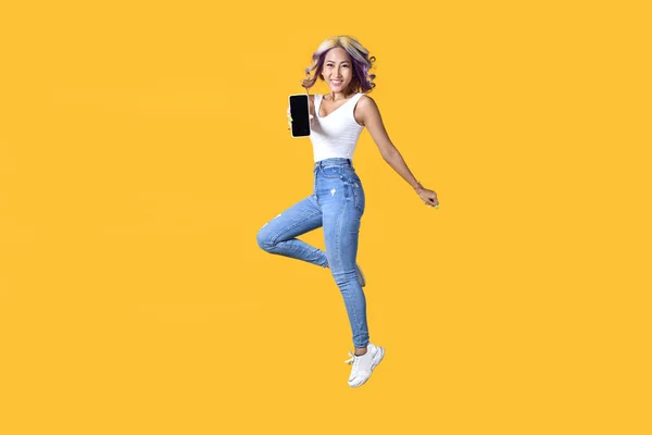 Полнометражный Портрет Молодой Азиатки Держащей Смартфон Прыгающим Желтом Фоне Веселая — стоковое фото