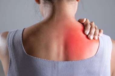 Asyalı kadının omuz ağrısı var. Başka bir elle acı çeken omuz tutan bir kadın. Vücut-kas problemi, sağlık ve ilaç sorunları olan insanlar..