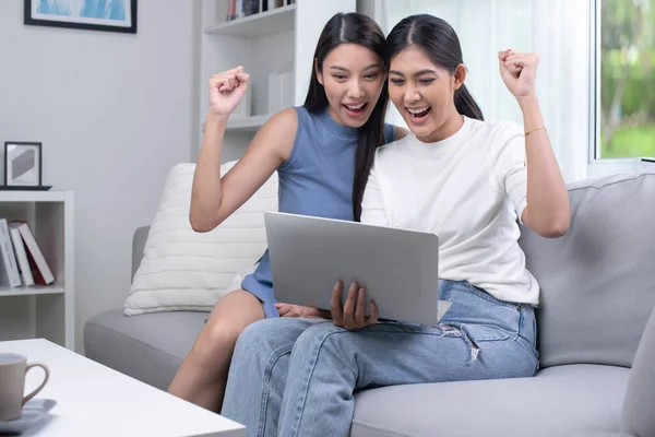 Счастливая Азиатская Пара Лесбиянок Использующая Ноутбук Гостиной Счастливо Поднимая Руки — стоковое фото