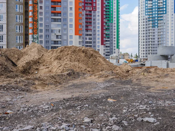 Staveniště Hromadami Písku Betonových Kruhů Popředí Nových Barevných Výškových Budov — Stock fotografie