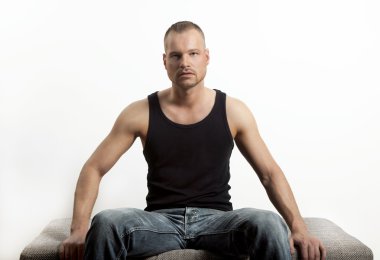 genç adam oturuyor, kameraya bakıyor