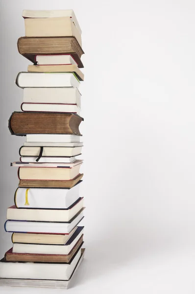 Une pile de livres nouveaux et anciens sur un fond gris blanc — Photo