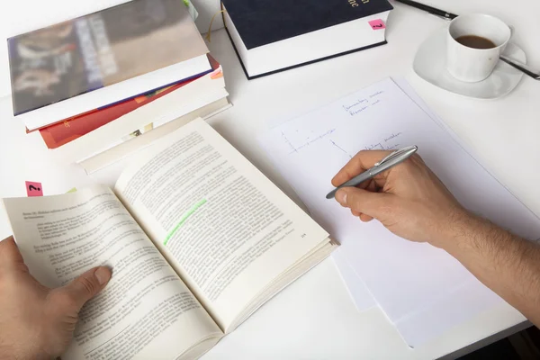 Studente che impara, prendendo appunti, su una scrivania con libri — Foto Stock