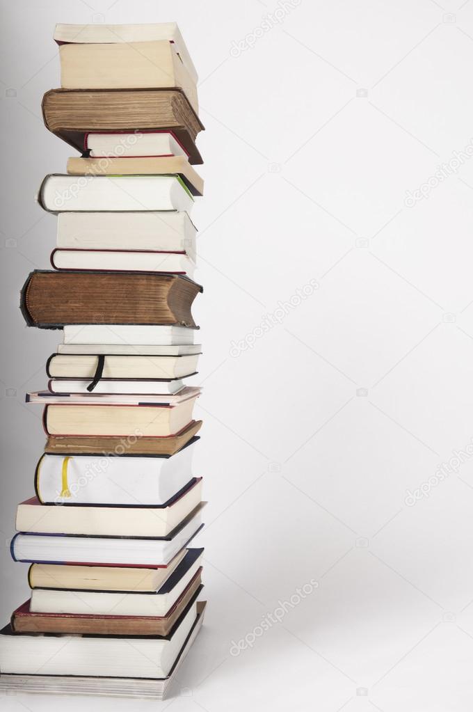 A pile of new and old books on a white grey background