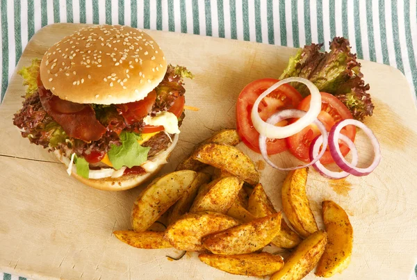 Burger with potato wedges on board — Stock Photo, Image