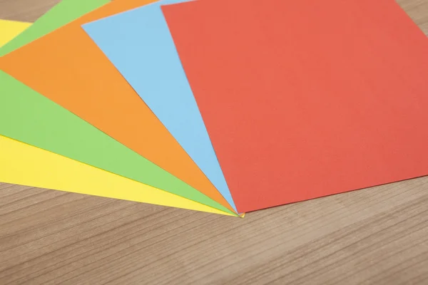 Papel colorido sobre fundo de madeira — Fotografia de Stock