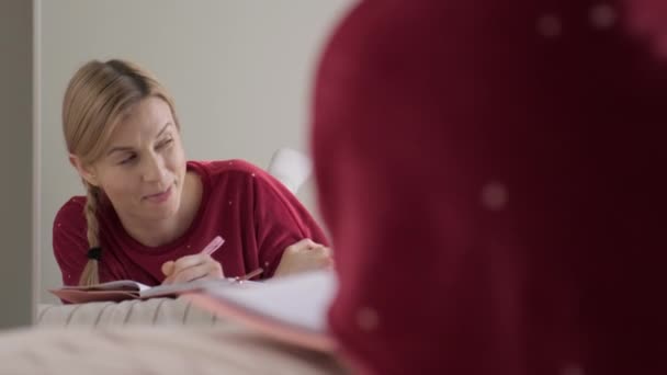 Mujer en la cama escribiendo en el diario. — Vídeo de stock