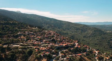 Aerial view of small Greek village Tymfristos in the mountain with curvy road