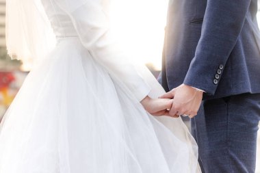 Düğün temalı çift gün batımında el ele tutuşuyor, aşıkların düğün günündeki resimleri.