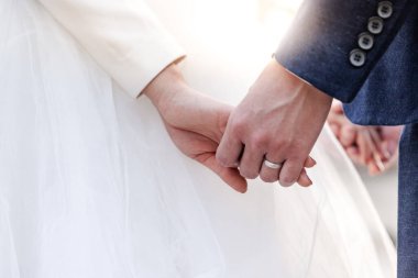 Düğün temalı çift gün batımında el ele tutuşuyor, aşıkların düğün günündeki resimleri.