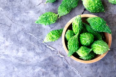 Taze Bitter Sebzesi ahşap kasede eski ahşap masa arka planında, üst manzara