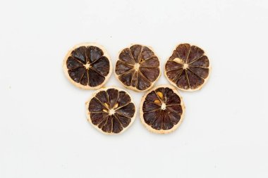 Beyaz arka planda kurutulmuş limon dilimleri.