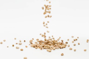 Beyaz arka planda dağınık fıstıklar.