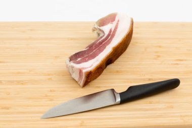 Beyaz arka planda pastırma ve bıçak.