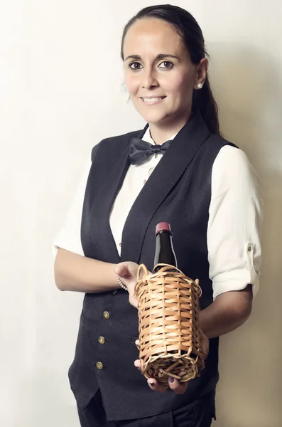 Beautiful waitress offering a bottle of wine — Stock Photo, Image
