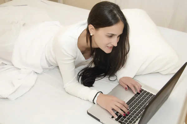 Mujer joven en la cama con ordenador —  Fotos de Stock