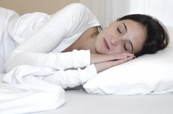 Mujer real y natural durmiendo entre sábanas blancas — Foto de Stock