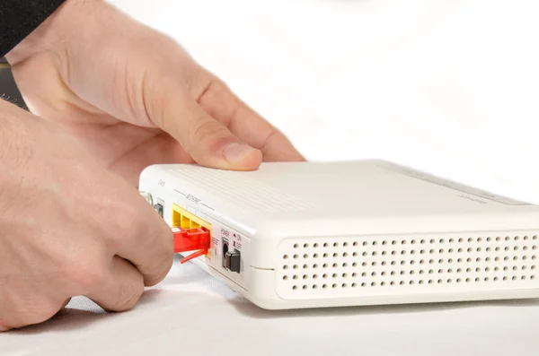 Hand in the foreground while connecting a router — Stock Photo, Image