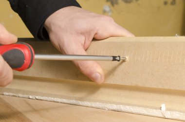 ahşap üzerine bir tornavida kullanarak eller