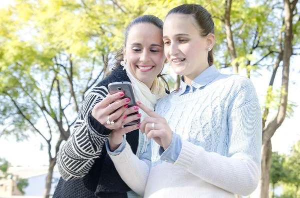 Two women using a smartphone — Stock Photo, Image