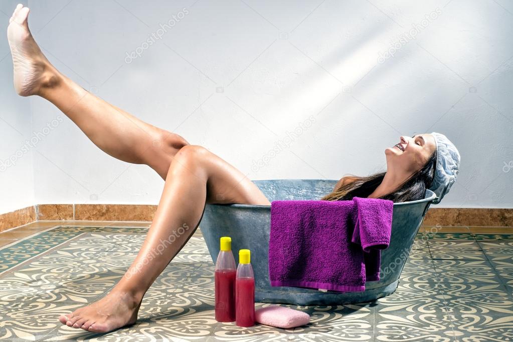 Young woman in an old bathtub
