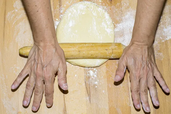 Mãos com massa de amassar rolando — Fotografia de Stock