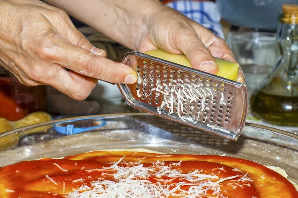 Using a grater to grate cheese — Stock Photo, Image