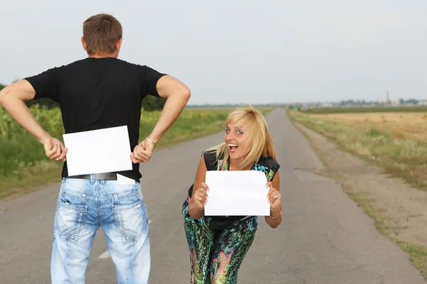 Grappige paar toont een leeg vel papier — Stockfoto