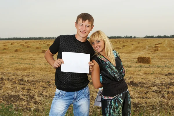 Lustiges Paar zeigt leeres Blatt Papier — Stockfoto