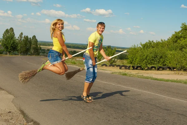 Lyckliga unga par hoppa med en kvast — Stockfoto
