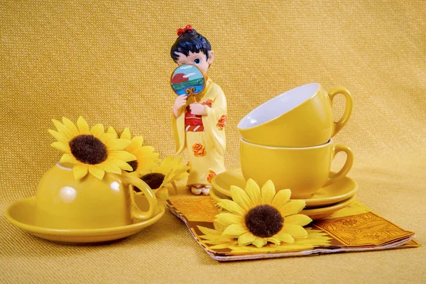 Koffie kopjes en schotels en beeldje geisha — Stockfoto