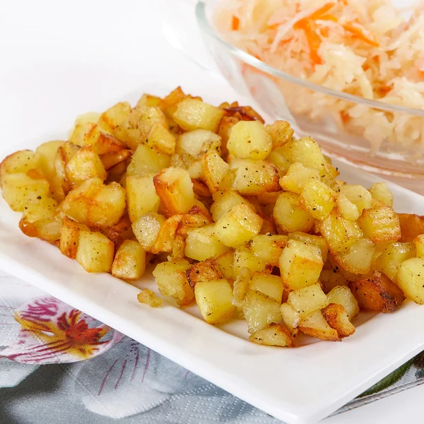 Fried potato cubes with sour cabbage — Stock Photo, Image