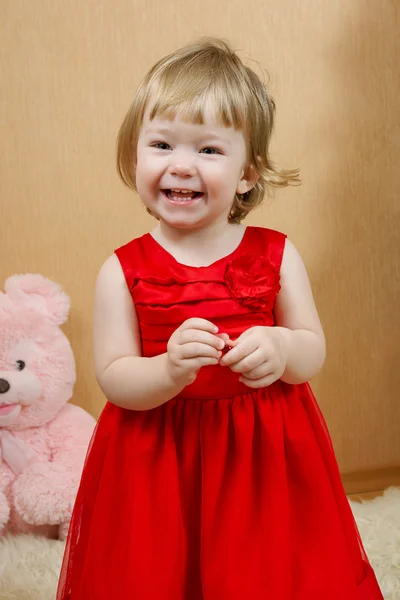 Roztomilá smějící se dívka v červených šatech — Stock fotografie